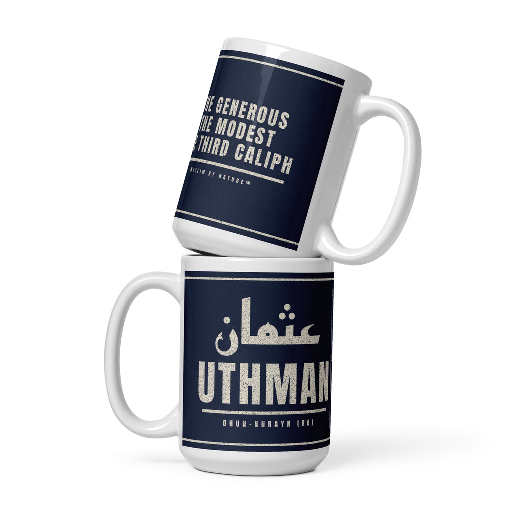 Muslim By Nature™ LEGACIES: MEN №03 Uthman (RA) 15oz white mug – navy wrap with Kufic Arabic name and UTHMAN in cream – front view