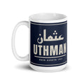 Muslim By Nature™ LEGACIES: MEN №03 Uthman (RA) 15oz white mug – navy wrap with Kufic Arabic name and UTHMAN in cream – handle on left